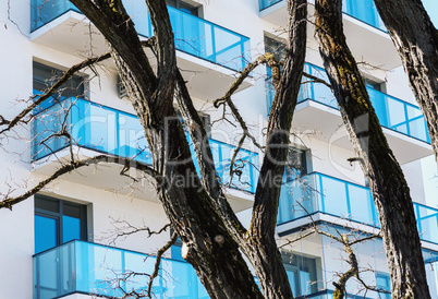 Residential building balconies with trees in foreground