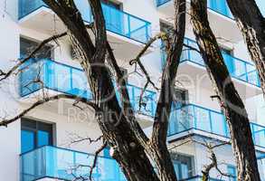 Residential building balconies with trees in foreground
