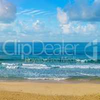 Deserted sandy beach of the Indian Ocean. In the blue sky cumulu