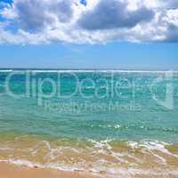 Deserted sandy beach of the Indian Ocean. In the blue sky cumulu