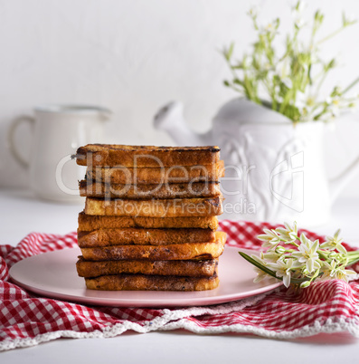 fried French toast on a ceramic pink plate