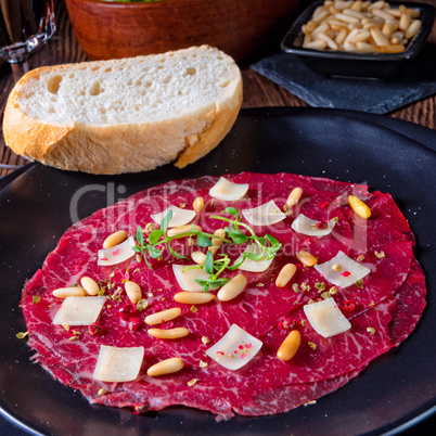 Carpaccio of beef with pine nuts, colorful pepper and Parmesan c