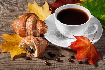 Cup of black coffee with croissants