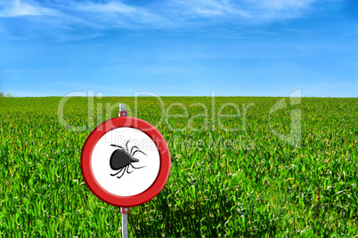 Green field and tick warning sign