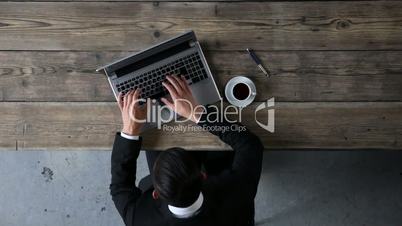 Top view of man typing on laptop