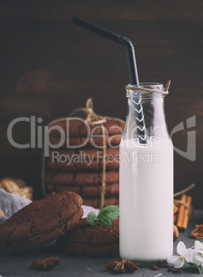 full glass bottle with milk and a black straw