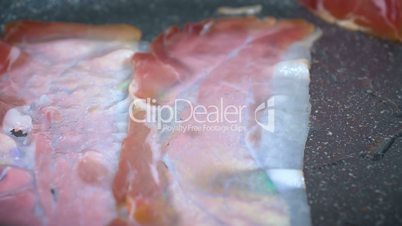 Closeup of bacon strips frying on a grill