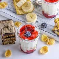 yogurt in transparent glass with syrup and banana