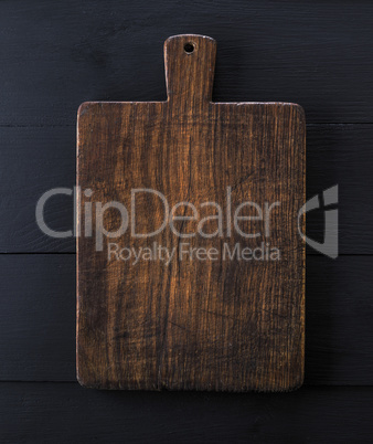 very old brown kitchen cutting board with handle