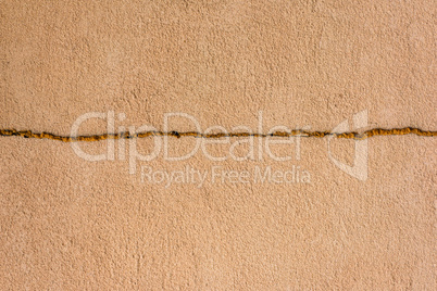 yellow cement wall with a crack