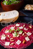 Carpaccio of beef with pine nuts, colorful pepper and Parmesan c