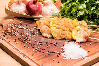 raw chicken skewers marinated with lemon on a wooden board