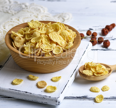 corn flakes in a wooden bowl on a white board