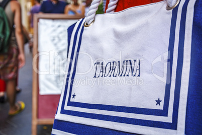 close-up view of a white bag with the inscription Taormina sewn on top