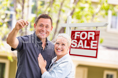 Caucasian Couple in Front of For Sale Real Estate Sign and House