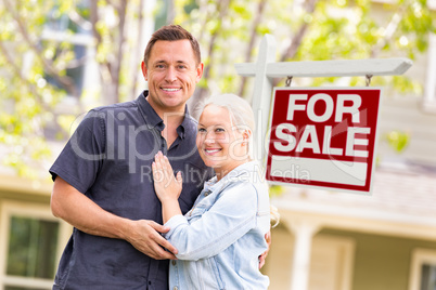 Caucasian Couple in Front of For Sale Real Estate Sign and House