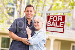 Caucasian Couple in Front of For Sale Real Estate Sign and House