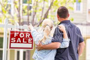 Caucasian Couple Facing and Pointing to Front of For Sale Real E