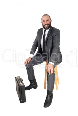 Business man sitting with his and briefcase Business man sitting with his and briefcase