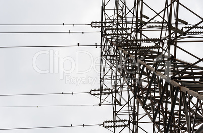 Looking up large electrical tower on overcast day.