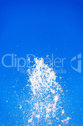 Abstract water splash into clear blue sky.