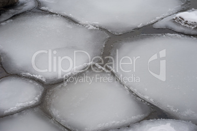 Irregular ice floes floating on water surface.