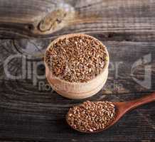flax seeds in a wooden bowl and spoon