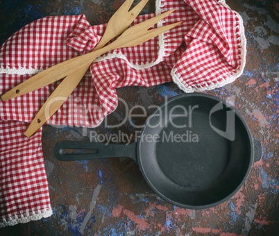 round empty black cast-iron frying pan with a red napkin