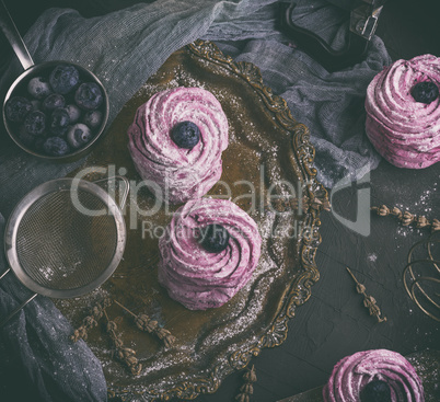 round airy marshmallow with blueberries on an iron plate