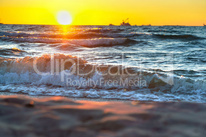 red yellow sunset on the sea shore in the surf of the waves of the Baltic sea and a magnificent sunrise