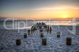 Ruins of the old Naples Pier at sunset on the ocean