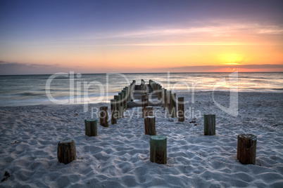 Ruins of the old Naples Pier at sunset on the ocean