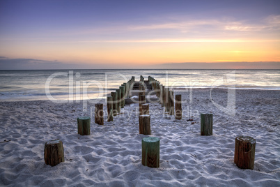 Ruins of the old Naples Pier at sunset on the ocean