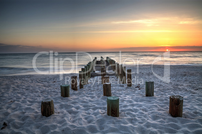 Ruins of the old Naples Pier at sunset on the ocean