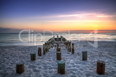 Ruins of the old Naples Pier at sunset on the ocean