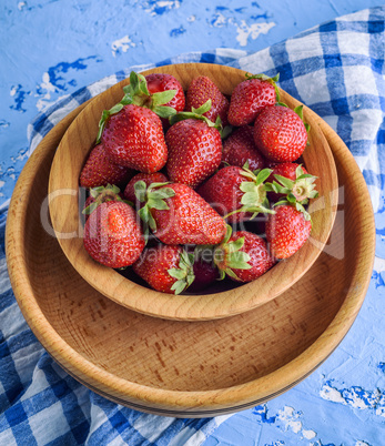 fresh ripe red strawberry in a brown wooden plate