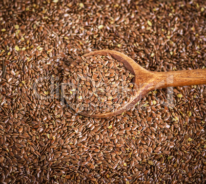 flax seeds in a wooden spoon on a pile