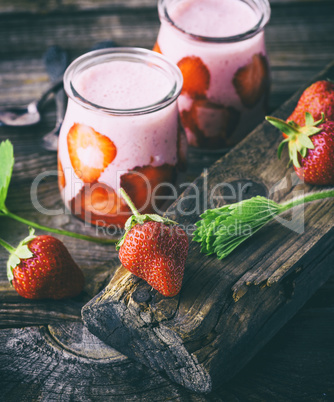 red strawberry and two glass jars of smoothies