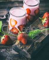 red strawberry and two glass jars of smoothies
