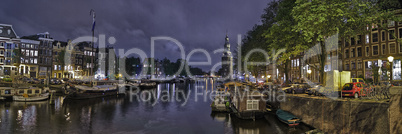 Panoramic View Of Amsterdam At Night At A Water Channel