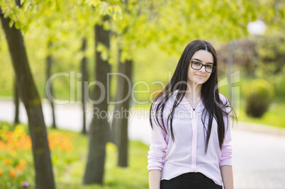 Teenager girl with glasses looking at camera and smiling