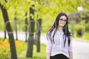 Teenager girl with glasses looking at camera and smiling