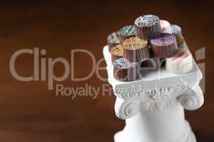 Stack of Fine Artisan Chocolates Stacked On White Pillar Column