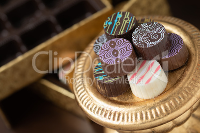 Artisan Fine Chocolate Candy On Gold Pillar Serving Dish