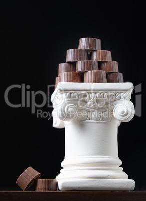 Stack of Fine Artisan Chocolates Stacked On White Pillar Column