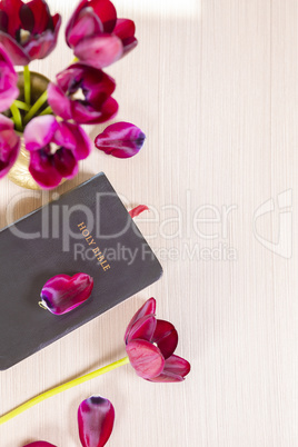 Holy Bible and flowers on wood table