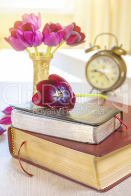 Holy Bible and old gold alarm clock on wood table