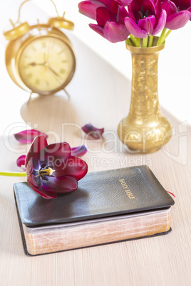 Holy Bible with flowers on wooden table