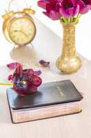 Holy Bible with flowers on wooden table