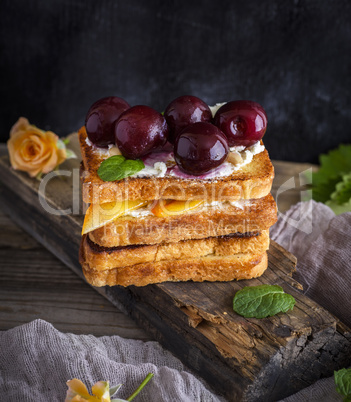 fried square pieces of white bread with soft curd and cherries
